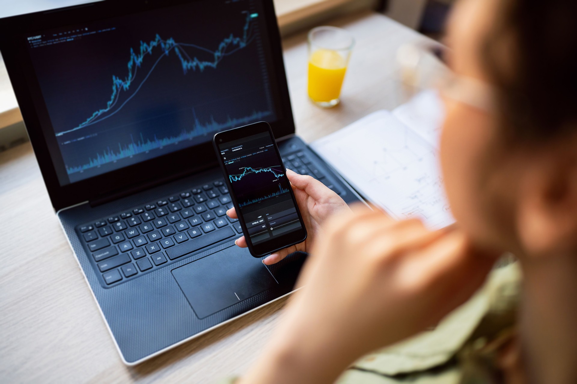 Young woman doing cryptocurrency business trading at her home